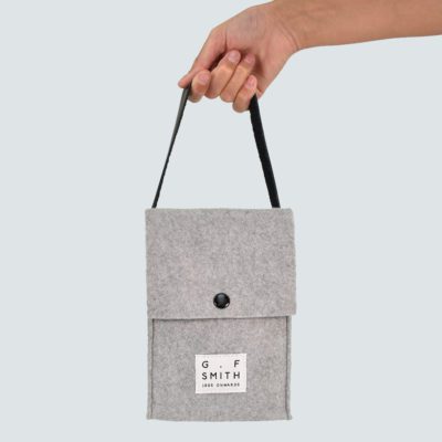 grey felt cube bag with back leather straps held by hand