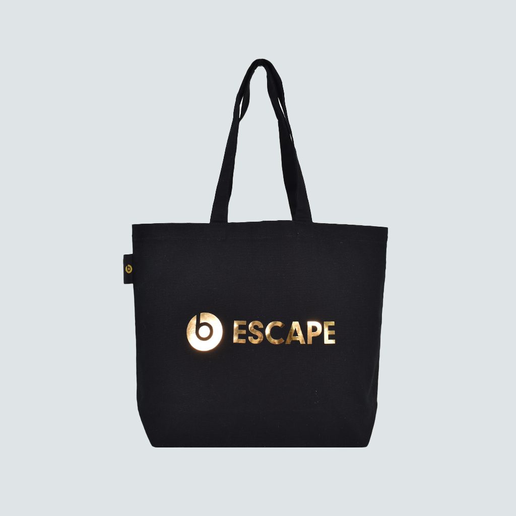 black square shopping bag with gold mirror logo ESCAPE on grey background