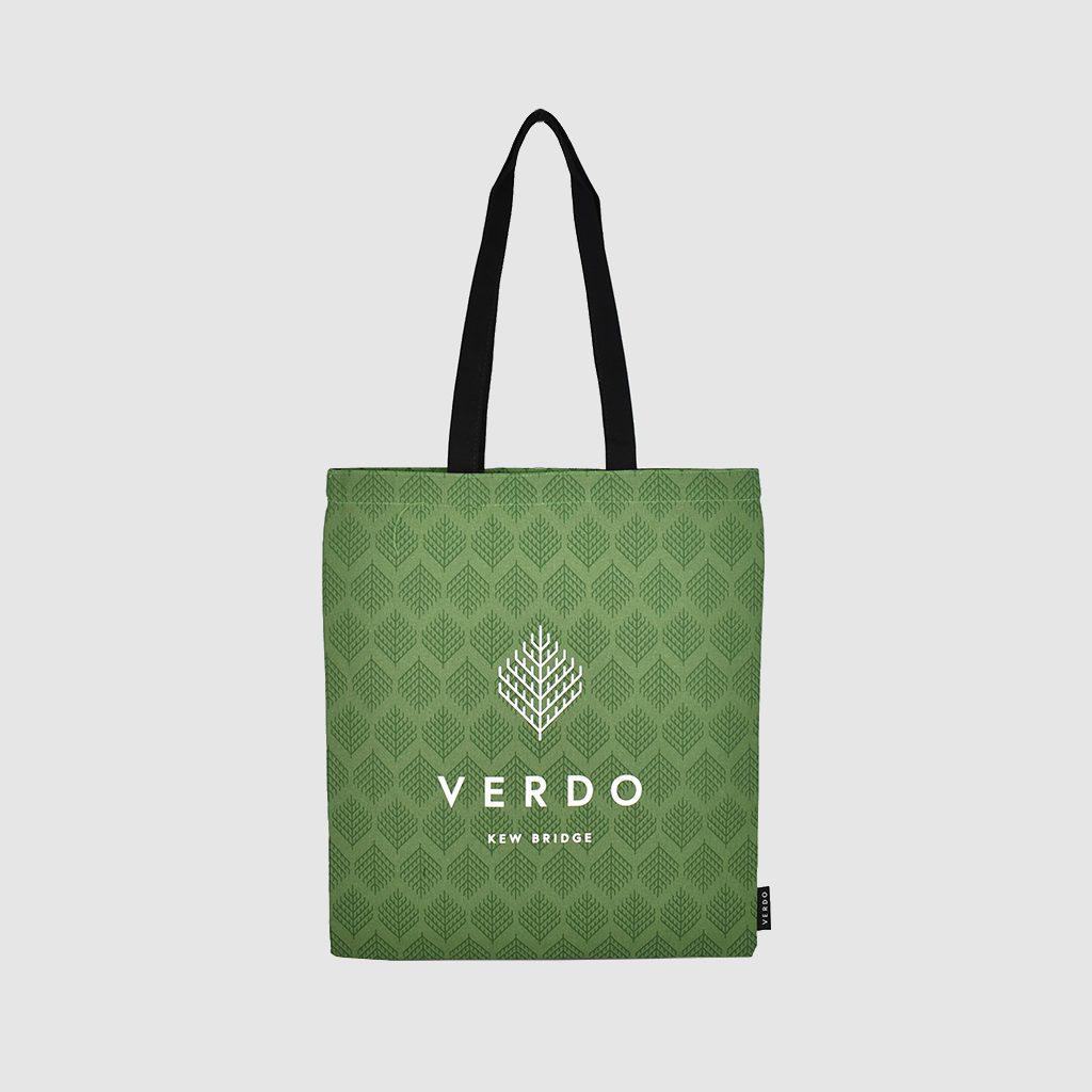 green tote bag with white print all over and black handles