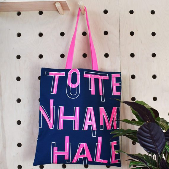 navy blue tote bag with neon pink print and handles