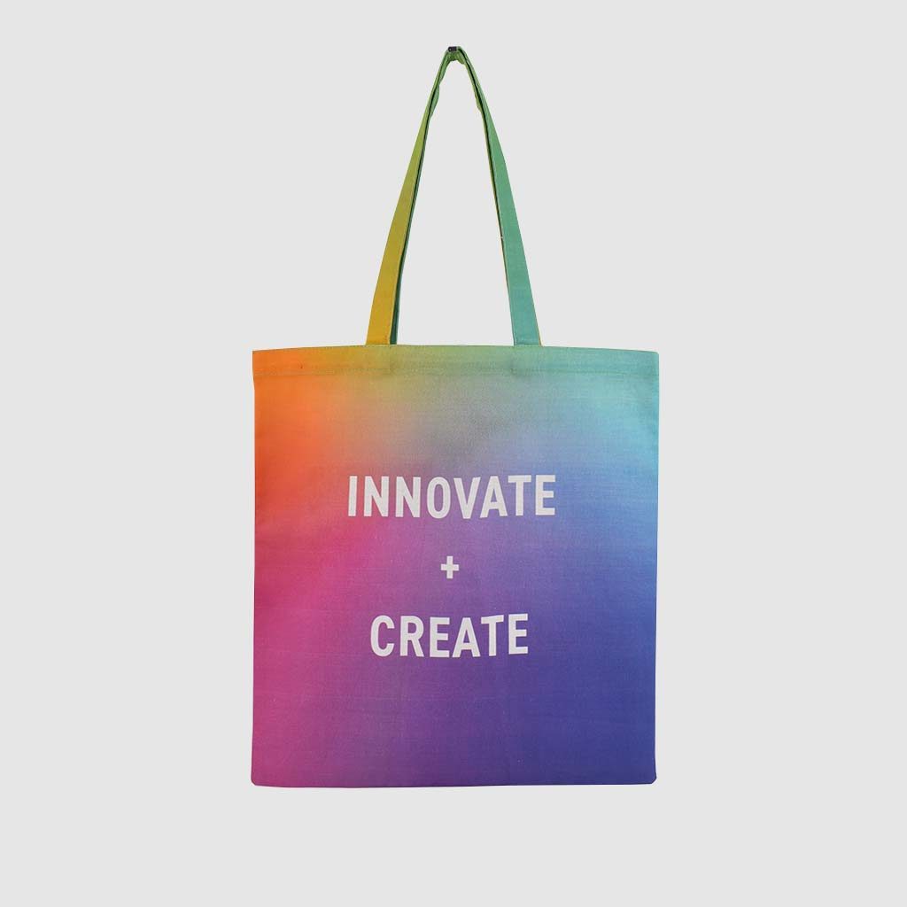 ombre rainbow print all over bag with white text says Innovate + Create