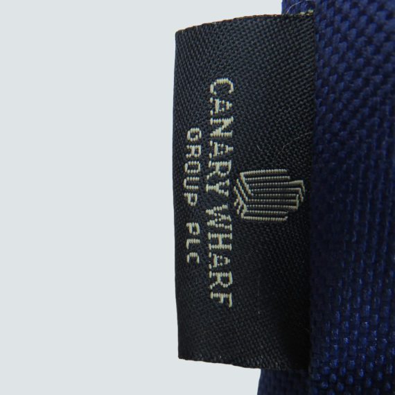 black woven label with gold logo on side seam of bag